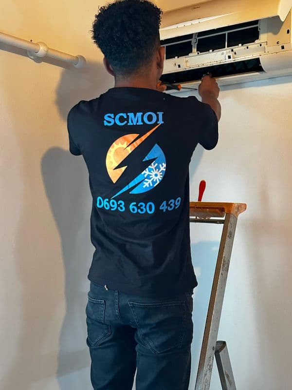 Technicien SCMOI en intervention sur un climatiseur à La Réunion